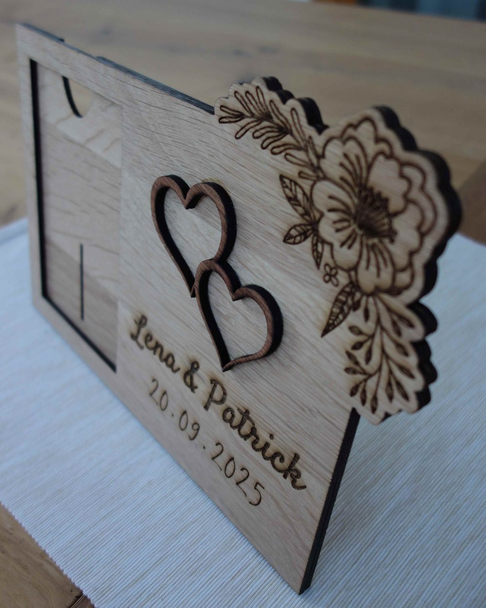 Personalisierter Bilderrahmen aus Holz zur Hochzeit mit zwei Herzen, Blumenranke und der Gravur „Lena & Patrick 20.09.2025“
